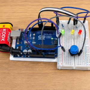 Semafor mini edukativ i ndërtuar me Arduino UNO Rev3, LED të kuq, të verdhë dhe jeshil, buton kontrolli dhe furnizim me bateri 9V.